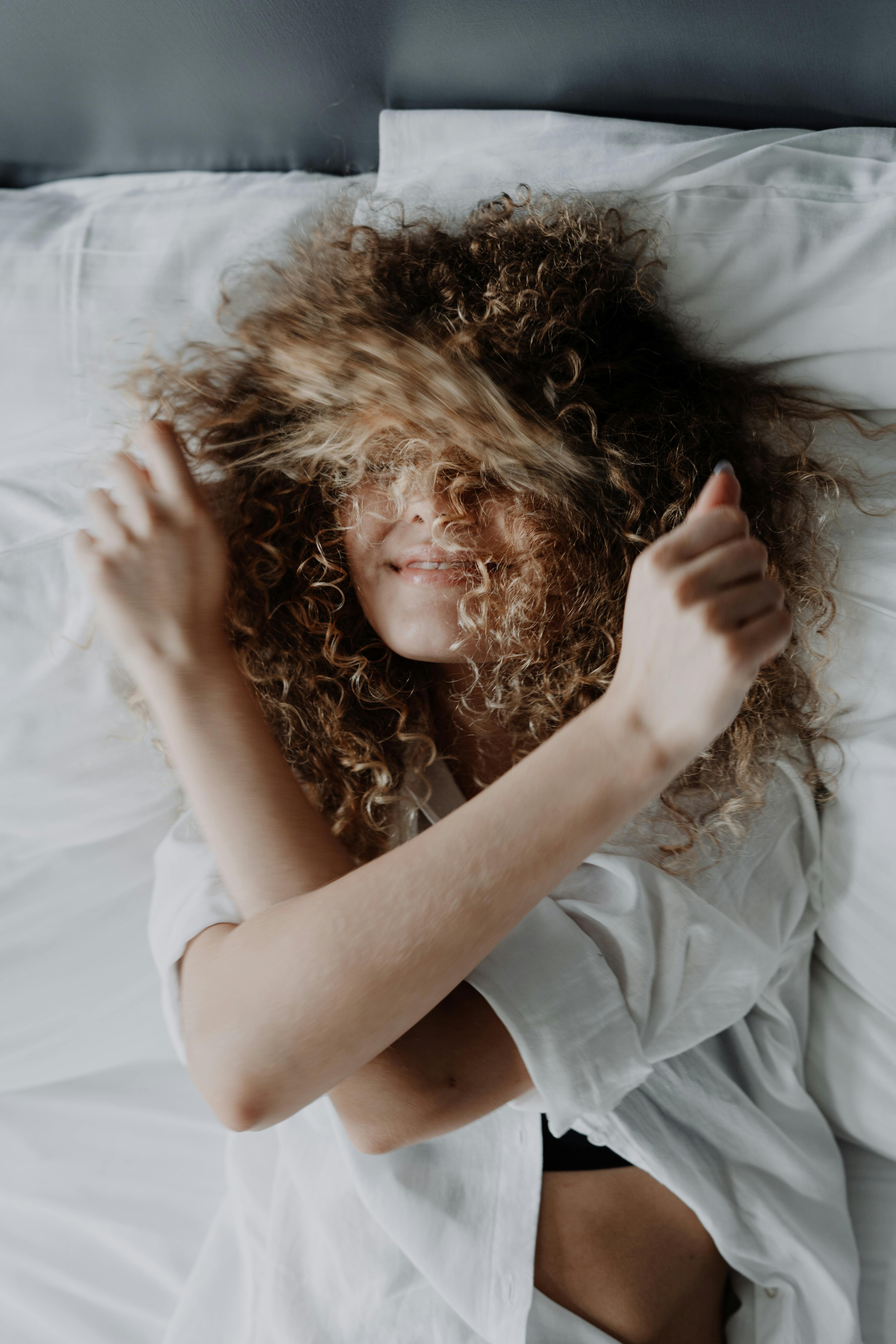 Woman in White Shirt Lying on White Textile · Free Stock Photo