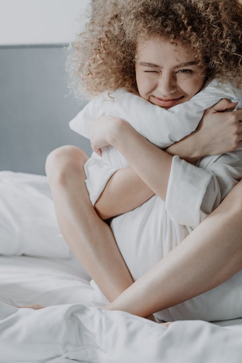 Free Woman in White Shirt Lying on Bed Stock Photo