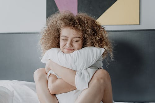 Free Woman in White Long Sleeve Shirt Lying on Black and White Wall Stock Photo