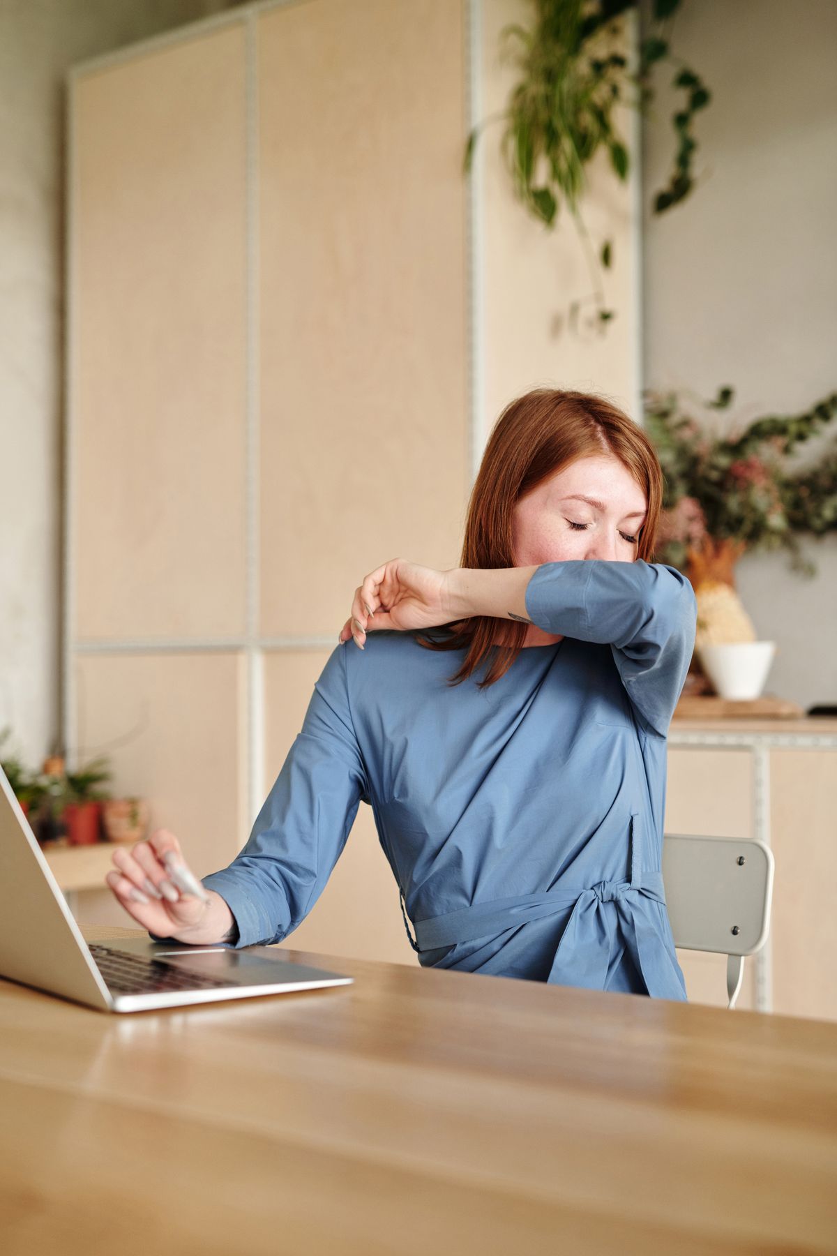 Woman sneezing from cat or dog dander indoors