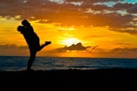 日落时分，海滩上情侣相拥的剪影，展现了爱情与宁静