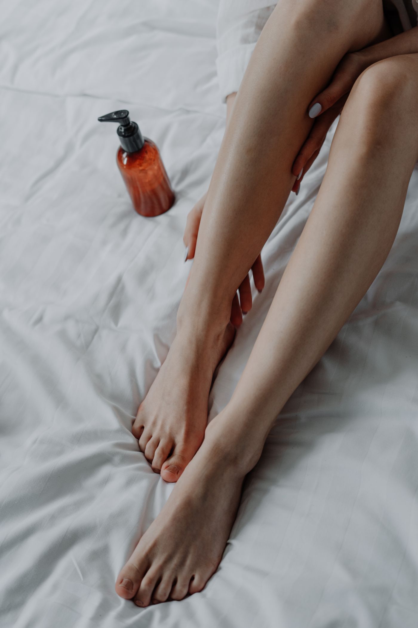 A woman caring for the skin on her legs at home