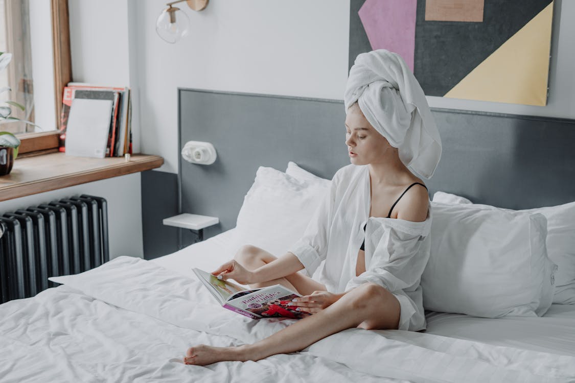 Free Woman in White Dress Sitting on Bed Stock Photo