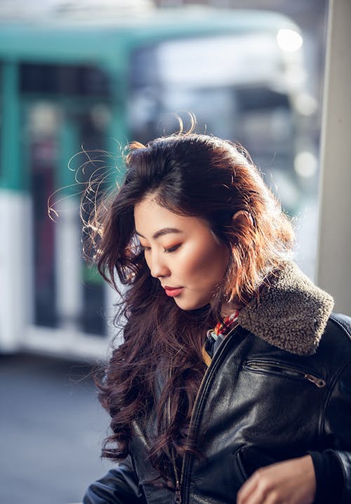 Modern ethnic woman in warm jacket on street