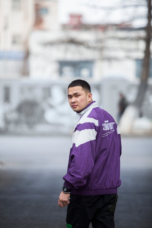 Asian man in sportswear standing on city street