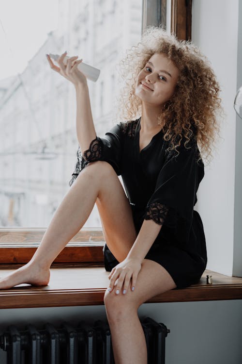 Free Woman in Black Long Sleeve Shirt Sitting on Brown Wooden Bench Stock Photo