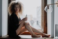 Woman in Black Dress Sitting on Brown Wooden Window