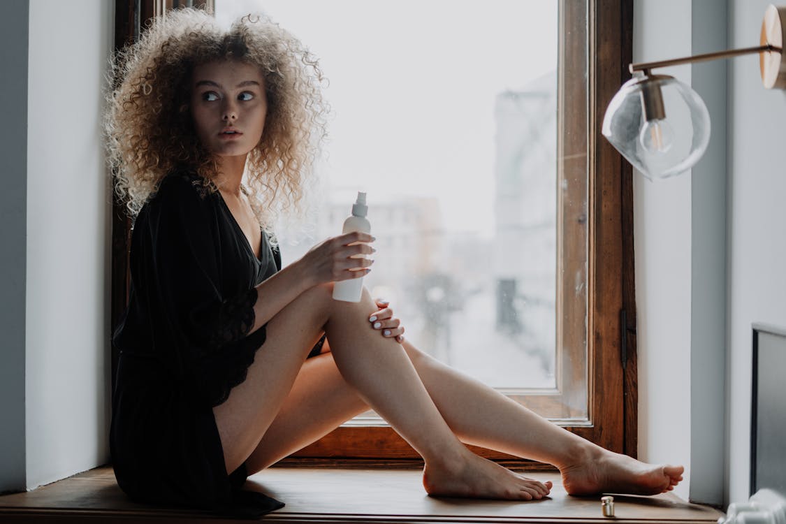 Free Woman in Black Dress Sitting on Brown Wooden Window Stock Photo