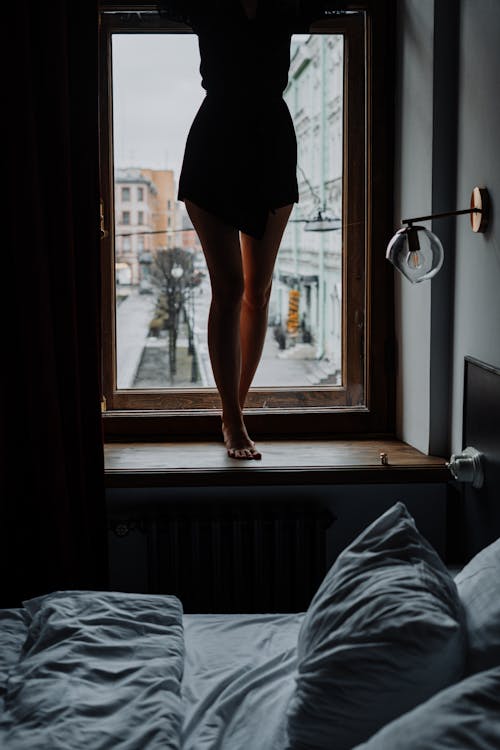 Woman in Black Skirt Standing Near Window