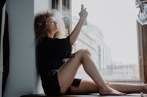 Free Woman in Black Dress Sitting on Window Stock Photo