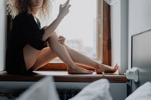 Woman in Black Dress Sitting on Window