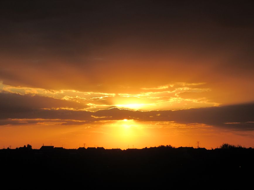 A breathtaking sunset with golden hues illuminating the sky over a silhouetted horizon.