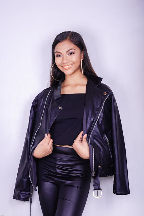 Stylish ethnic woman in black leather jacket in studio