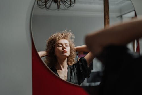 Woman in Black Shirt Standing Near Mirror