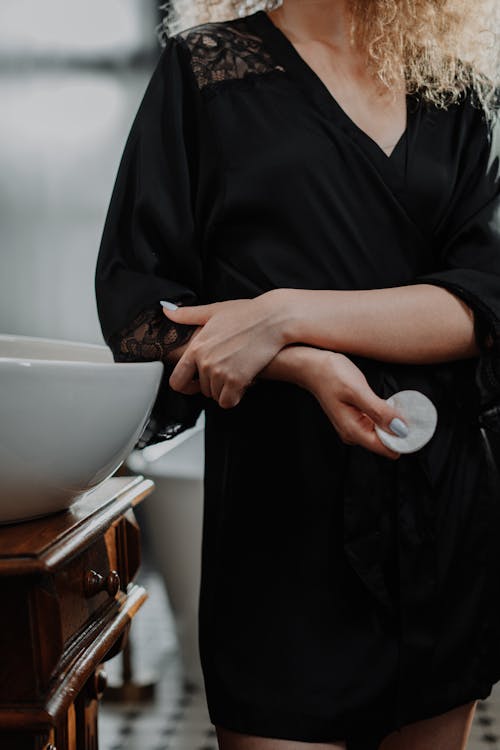 Woman in Black Robe Holding White Ceramic Bowl