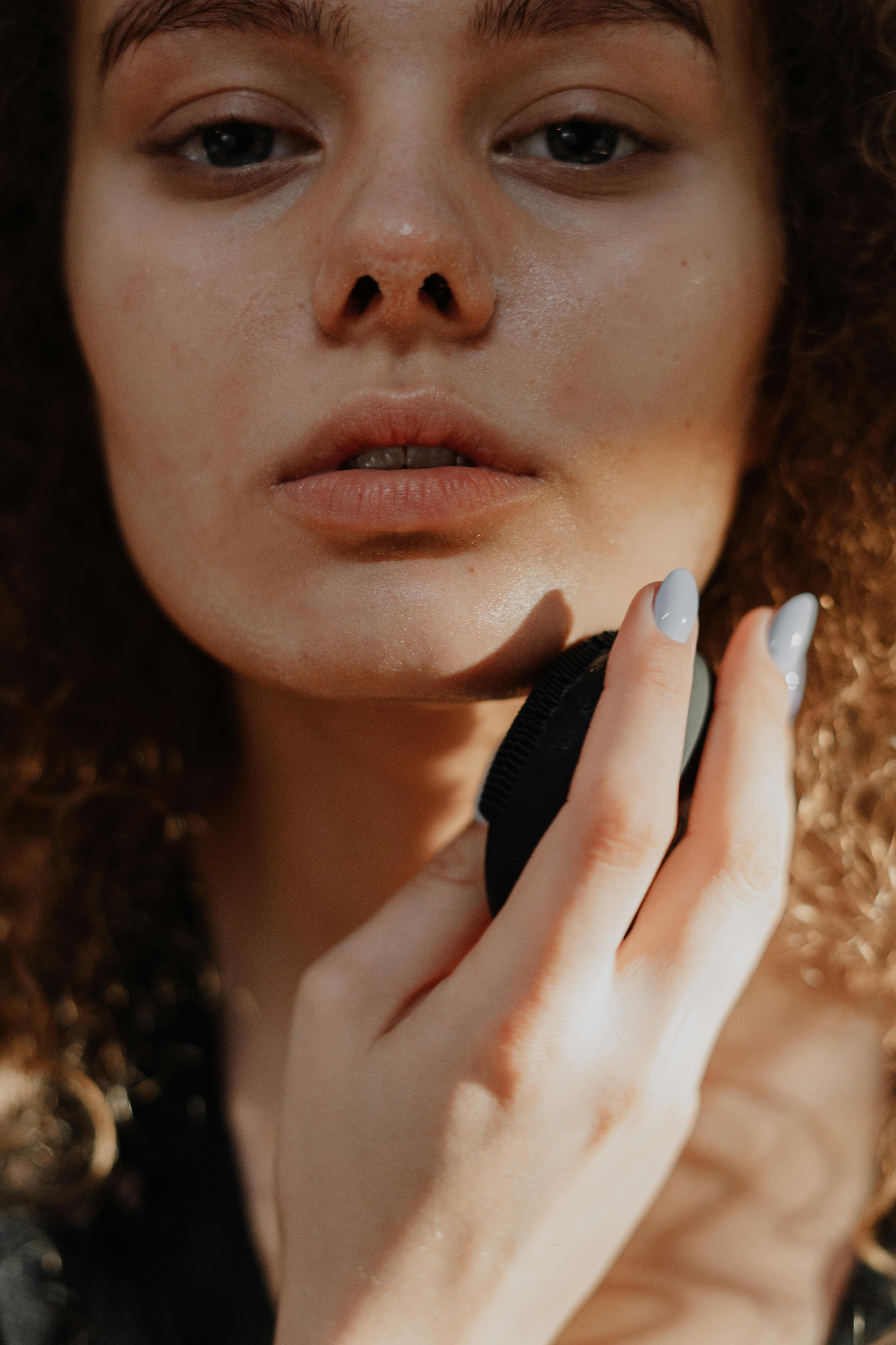 woman with brown hair holding her face