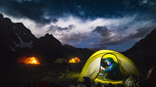 A Man in Blue Jacket in a Dome Tent