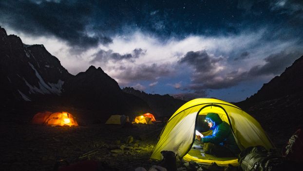 在阿富汗巴达赫尚风景优美的星空下，帐篷在夜间露营中显得格外明亮