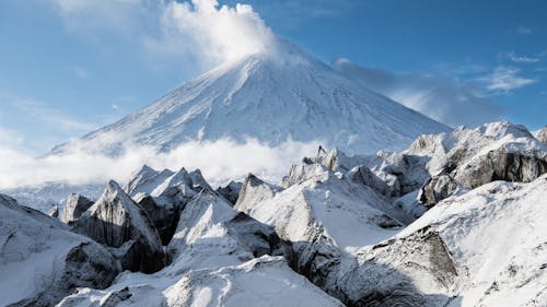 Free Clouds Above a Snow Covered Mountain Under Blue Sky Stock Photo