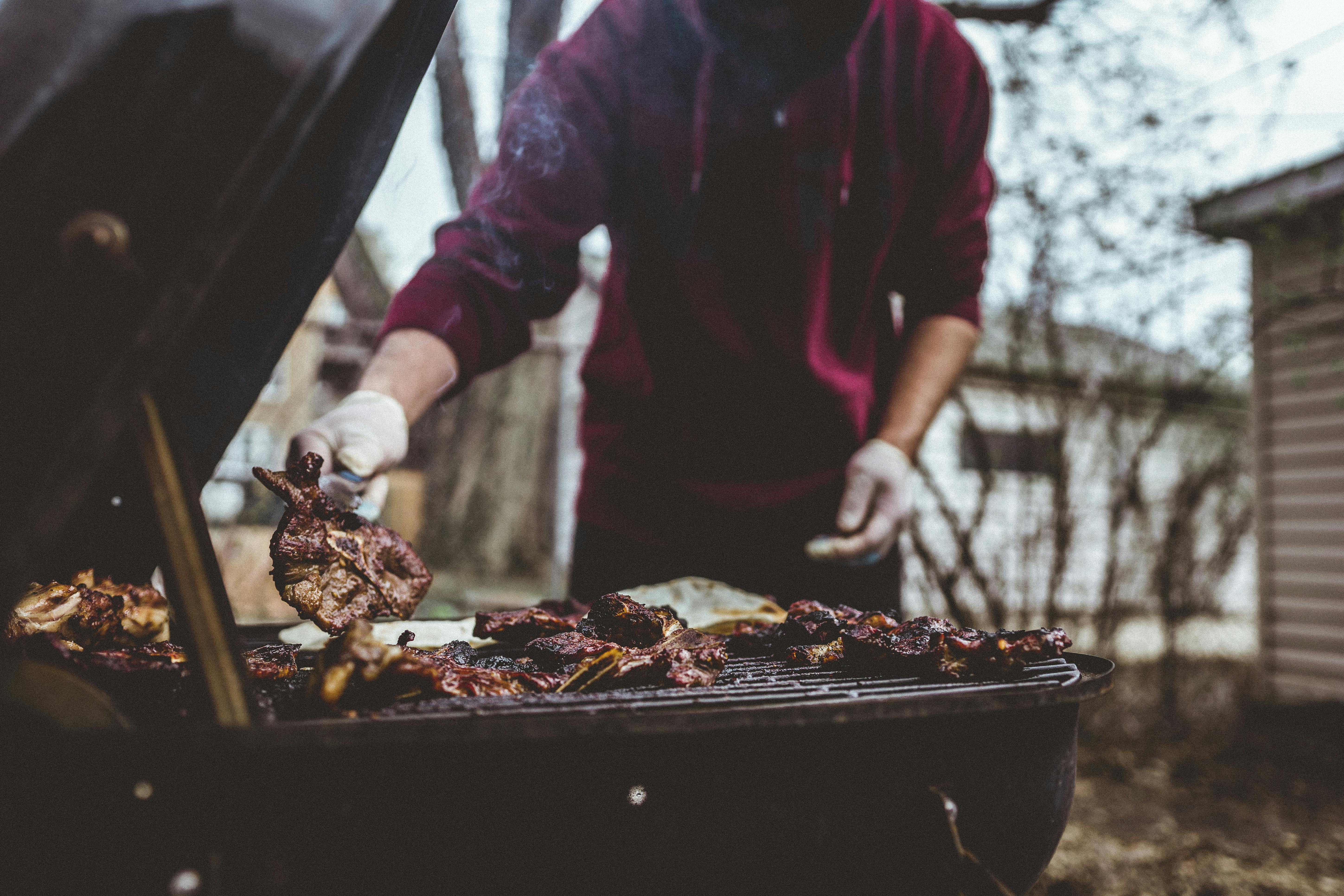 A person grilling meat outdoors in a Chicago backyard, capturing cozy barbecue vibes.