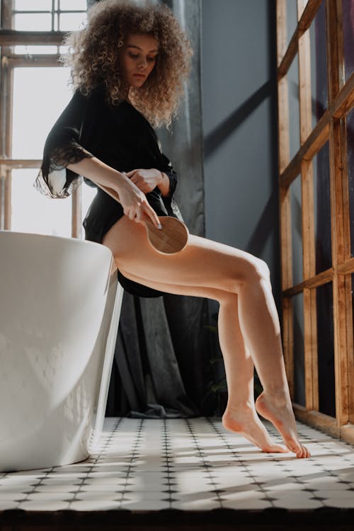 Woman in Black Long Sleeve Shirt and White Skirt Sitting on White Chair