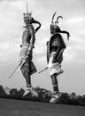 Man in Black and White Shorts Holding Stick Statue