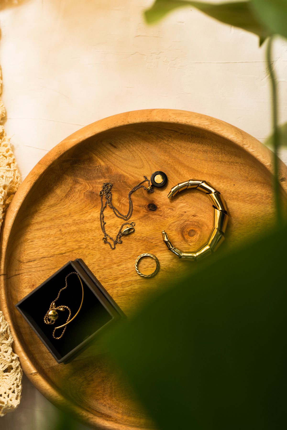 Silver and gold accessories arranged on a wooden tray
