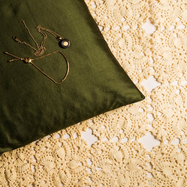 Gold Necklaces On Green Pillow 