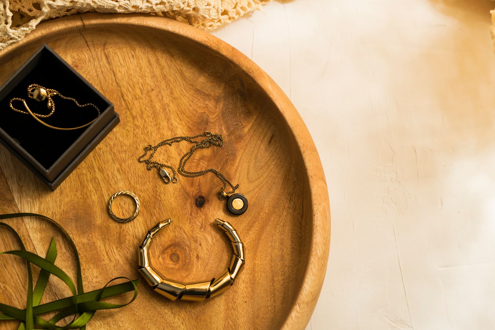 Gold jewellery pieces elegantly arranged on a wooden tray