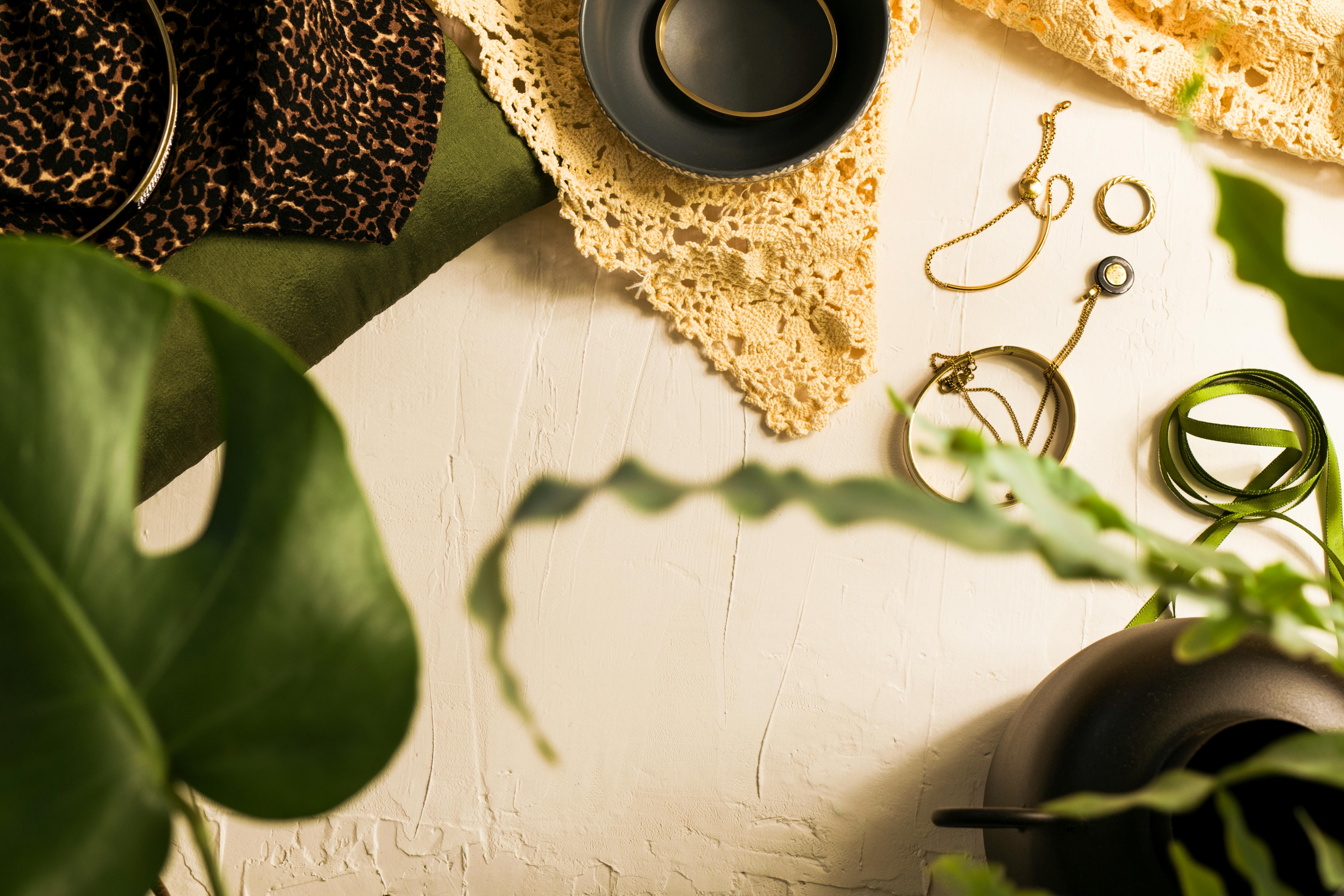 jewelries and a potted plant on a white surface