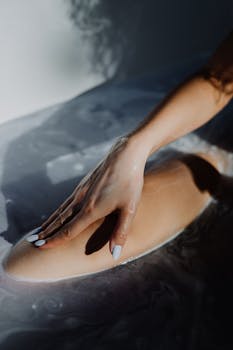 女性用手抚摸泡沫，享受舒缓的沐浴体验