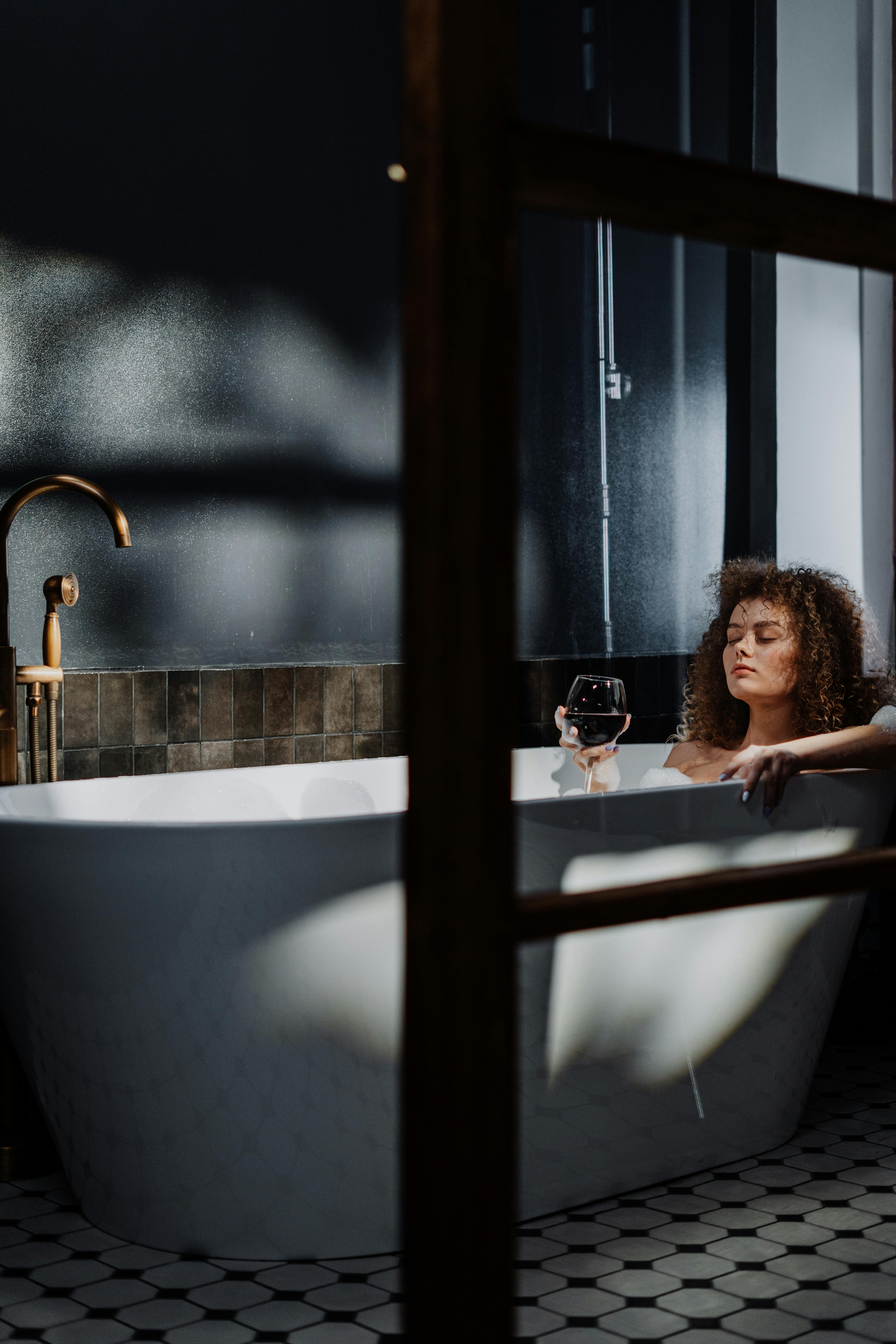 Woman in Bathtub Holding a Cup of Water · Free Stock Photo