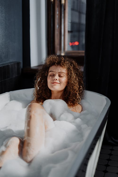 Topless Woman in White Bathtub