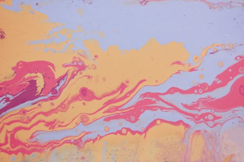 Abstract creative wallpaper with effect of spilled paints of pink orange and blue colors and bubbles on smooth surface