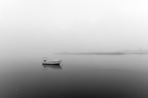 Grayscale Photo of Boat on Sea
