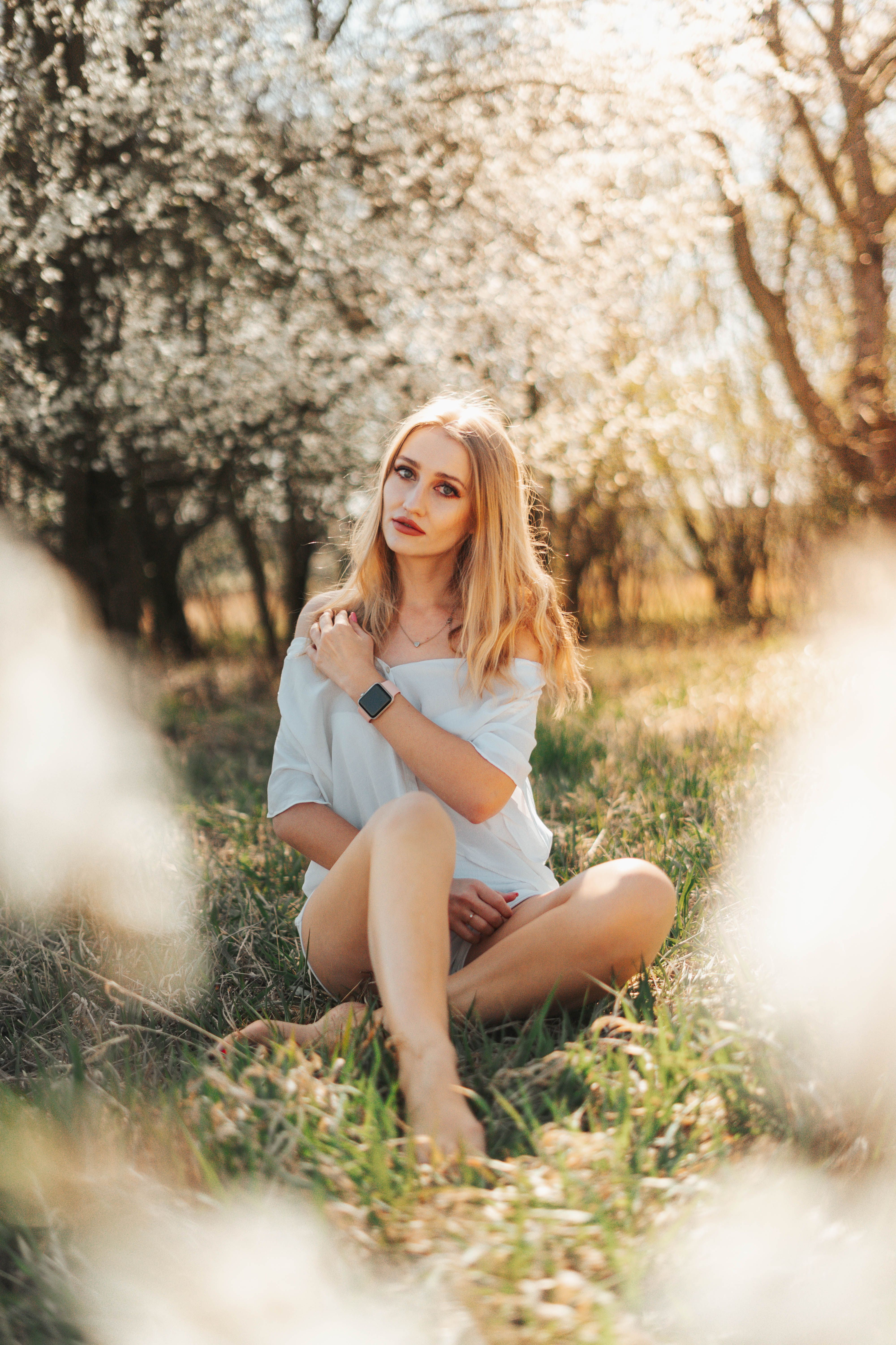 A Woman in White Top Sitting on Grass · Free Stock Photo