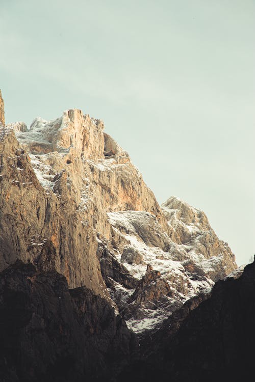 Snowy mountain ridge against cloudy sky