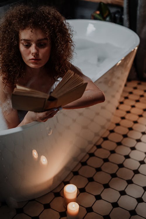 Woman in Black and White Polka Dot Dress Holding Book