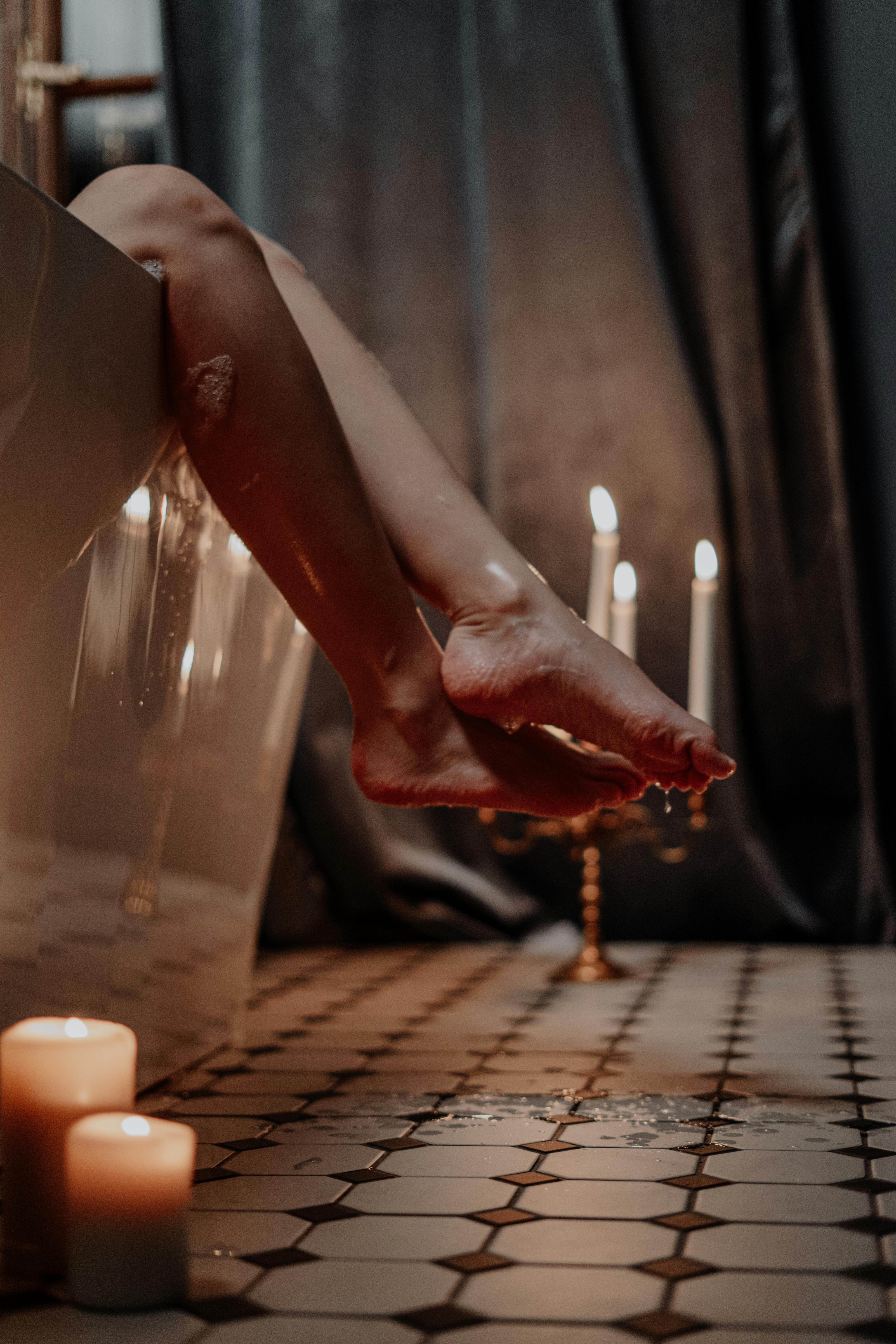 person holding lighted candle on table
