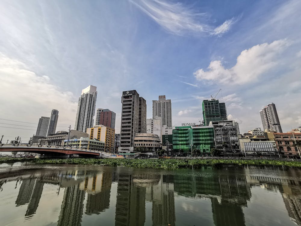 From below of contemporary towers located in office district of big city on Pasig river shore