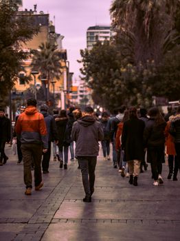 黄昏时分，伊斯坦布尔的街道上，一群熙熙攘攘的人群正从后方被镜头捕捉