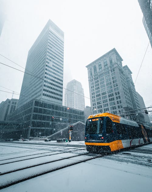 Free Yellow and Black Tram Near High Rise Buildings Stock Photo