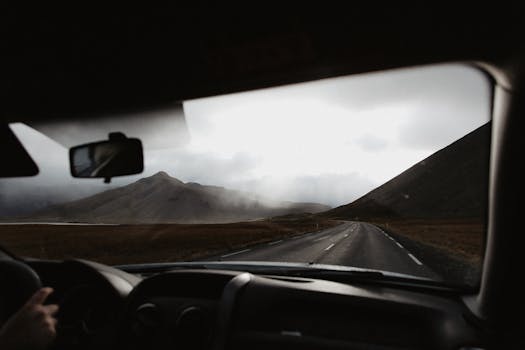 Captivating view of a foggy mountain landscape from a car interior during a road trip.