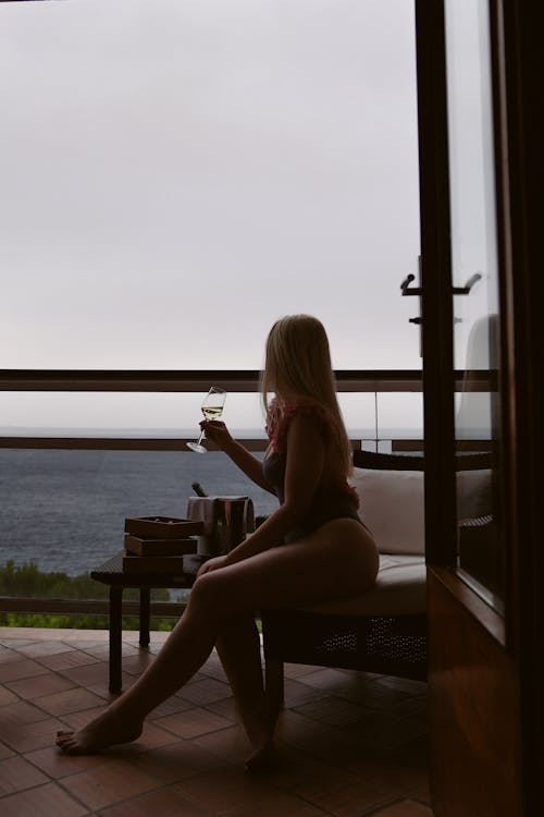 Free Woman Wearing Swimming Costume Drinking Wine and Looking At View Stock Photo
