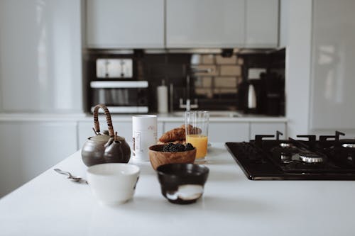 Free A Teapot, Bowls and Glass of Juice Near a Stove Stock Photo