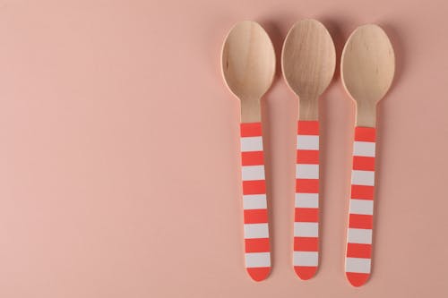 Close-Up Shot of Wooden Spoons on a Pink Surface