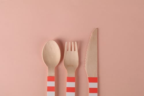 Close-Up Shot of Wooden Utensils on a Pink Surface