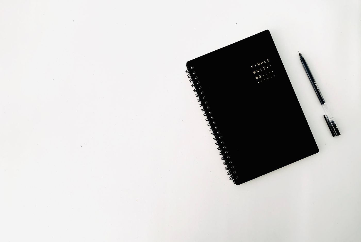 Notebook and pen on a white desk