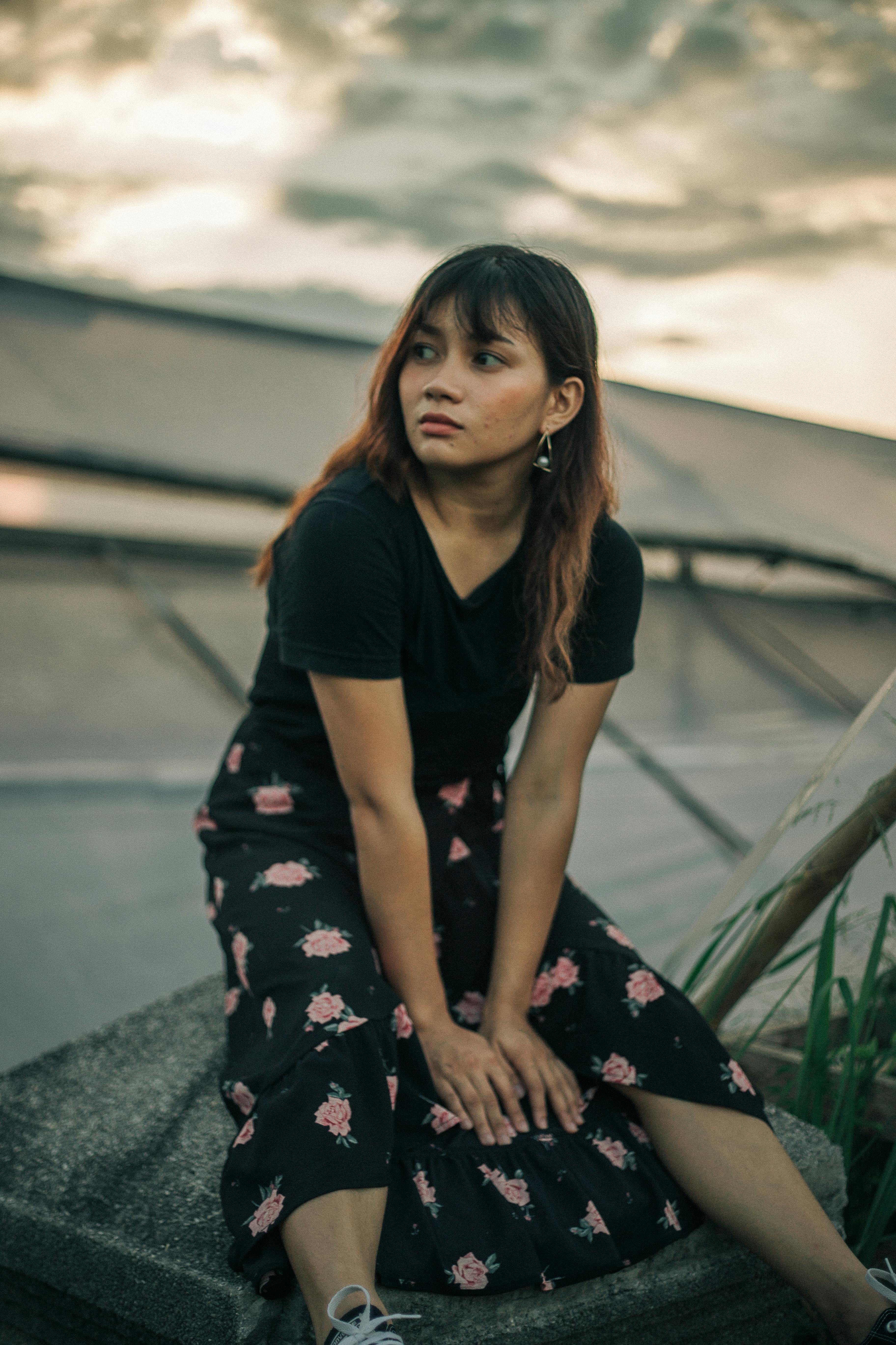 黄昏时分，一位体贴的女人坐在户外，散发着平静和宁静