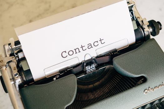 Close-up of a vintage typewriter with paper displaying the word 'Contact'.
